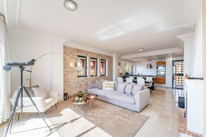 A modern living room with a sofa, coffee table, and a tripod. - Bonita Hills – Penthouse in Calahonda with Panoramic Sea Views & Large Terrace (Mijas)