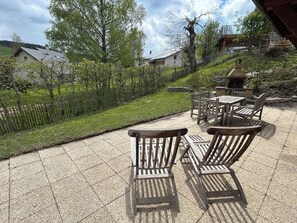 Eine Terrasse im Freien mit Holzmöbeln und Steinboden.