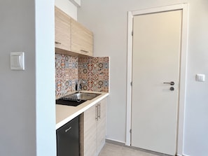 A compact kitchen with a sink, cabinets, and a dishwasher. - 6th Floor Loft in the Heart of Athens Ι by ΜΡS (Athina)