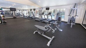 Ein Fitnessstudio mit Laufbändern, Kraftgeräten und Trainingsbällen.