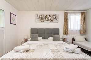 A bedroom with a large bed, two bedside tables, a headboard, and a window with curtains. - A2 - Cozy apartment with pool and spacious terrace, 2 min walk to beach (Omiš)