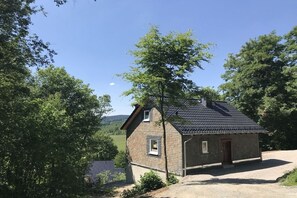 A small stone house with a sloped roof, a visible chimney, and a single door. - Holiday home in Brilon with swimming pool (Brilon)