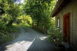 A gravel path leading to a stone building with a wooden door. - Holiday home in Brilon with swimming pool (Brilon)