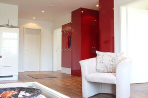 Una sala de estar moderna con un sofá blanco, armarios rojos y una mesita con una cesta.