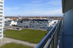 A residential area with a large white building, a green lawn, and a clear sky. - Holiday apartment with 2 bedrooms (Norderney)