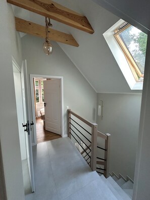Un escalier avec une rampe en bois et une lucarne.
