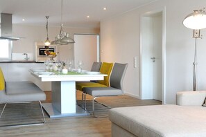 Eine moderne Küche mit Essbereich, einer Couch und einer Lampe.