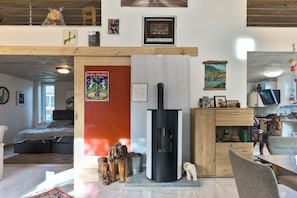 A modern living room with a fireplace, a bed, and a dining area. - Holiday home in Bell with swimming pool (Bell)