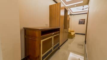 A hallway with a wooden cabinet, a ceiling fan, and a bicycle artwork on the wall.