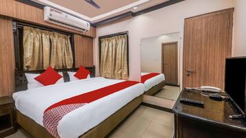 A hotel room with a bed, a desk with a telephone, and a mirror.