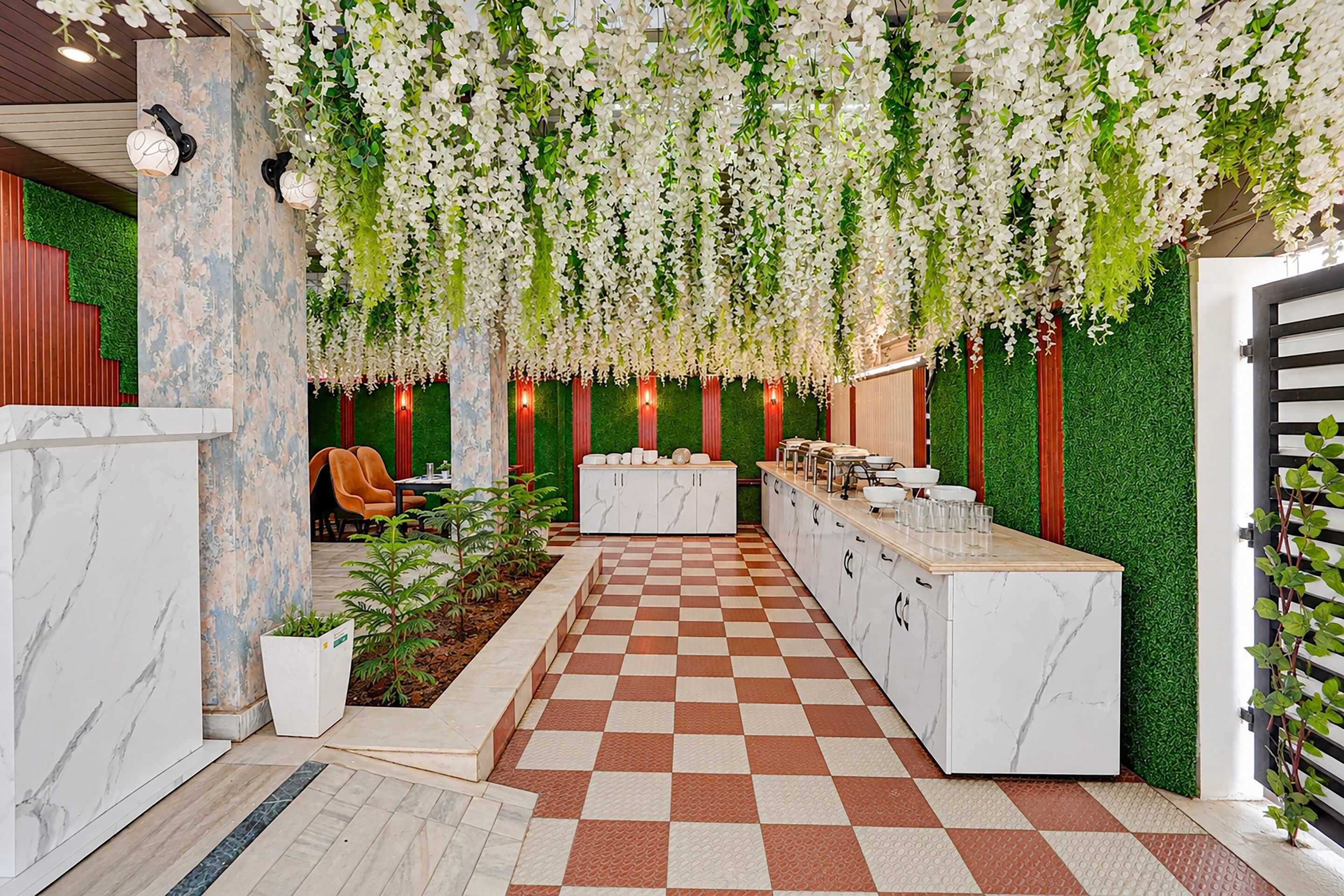 A hotel lobby with a checkered floor, a reception desk, and a green wall with vertical elements.