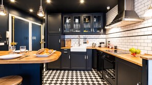 A kitchen with dark cabinets, a checkered floor, and a wooden countertop. - Paris - Bastille l AC & 10 min from Marais (Paris)