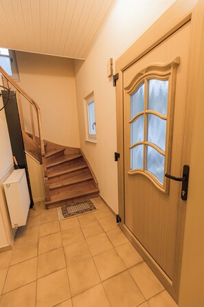 A staircase leading to a landing with a door and a window. - A comfortable home surrounded by beautiful nature, with a garden and parking (Obernhof)