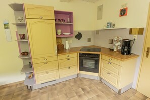 A compact kitchen with a dishwasher, oven, and a coffee maker.