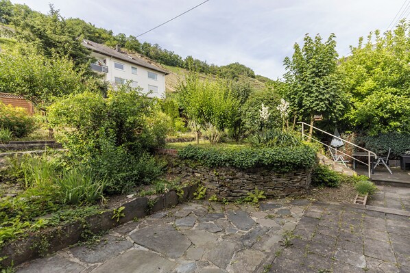 A stone pathway leading to a stone wall with a staircase.
