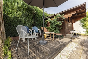 An outdoor patio with a table, chairs, and a pergola covered with vines. - A comfortable home surrounded by beautiful nature, with a garden and parking (Obernhof)