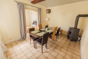 A dining area with a table, chairs, and a stove. - Cozy house surrounded by beautiful nature, with a garden and parking (Obernhof)