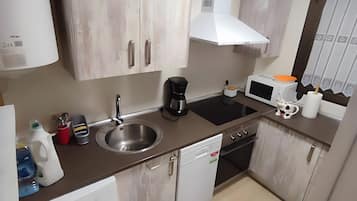 A modern kitchen with a washing machine, dishwasher, and a microwave.
