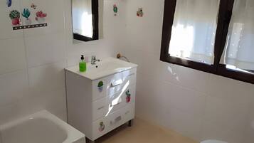 Un baño con bañera, inodoro y lavabo.