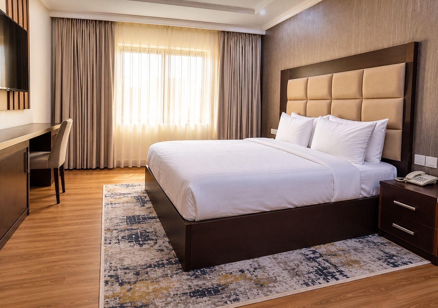 Quarto de hotel com uma cama grande, uma mesa e uma cadeira.