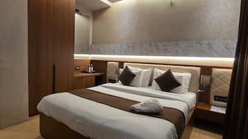 Una habitación de hotel moderna con una cama grande, un ventilador de techo y una pared de acento de mármol.