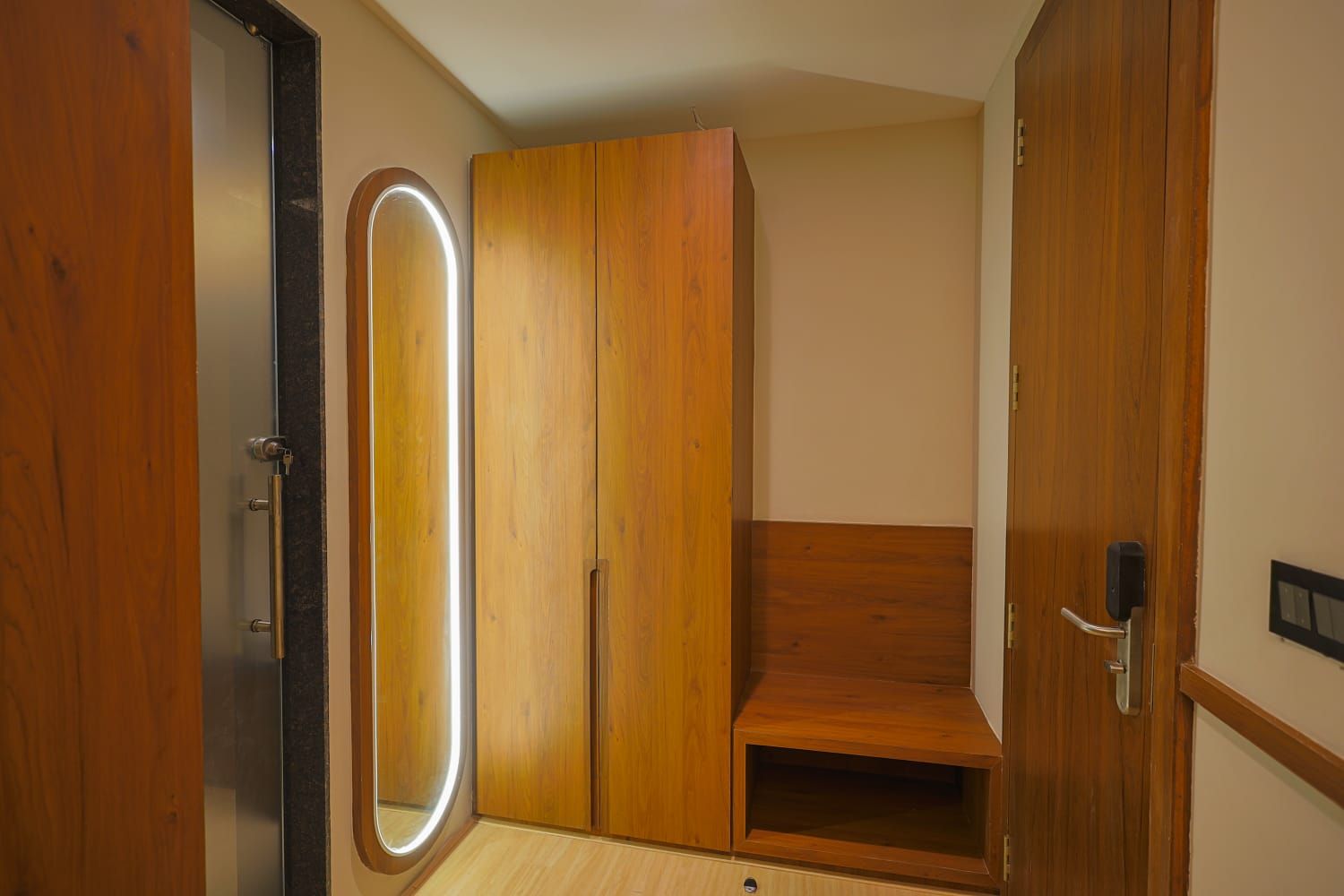 Una habitación con un armario de madera, un espejo y una puerta con picaporte.