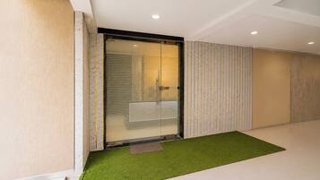 A modern interior with a sliding glass door, a green artificial turf area, and a patterned wall.
