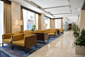 A hotel lobby with seating areas, large windows, and a modern design. - Harbour Suite Hotel (Manama)