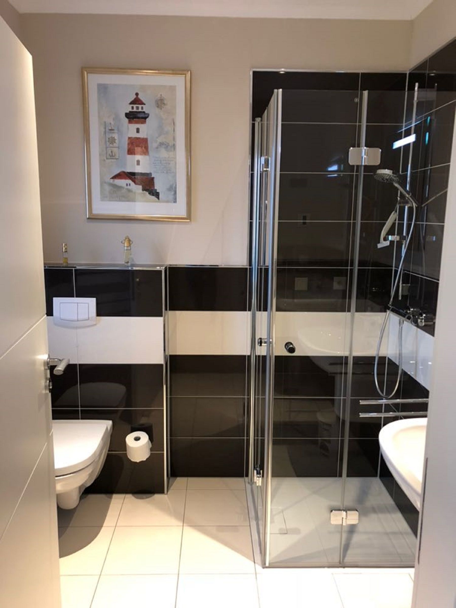 Ein modernes Badezimmer mit einer Duschkabine, einer Toilette und einem Waschbecken.