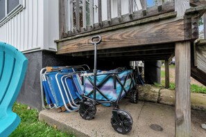 Ein blauer Kinderwagen mit gemustertem Bezug steht auf einem Betonpodest vor einem Haus.