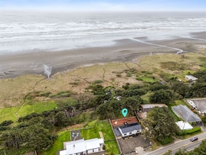 An aerial view of a coastal area with a house, a road, and a beach. - Sunset View Cottage - Brand new home on the Bluff (Moclips)