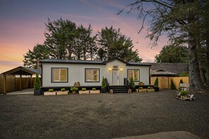 A single-story house with a front porch, a garage, and a driveway. - Sunset View Cottage - Brand new home on the Bluff (Moclips)