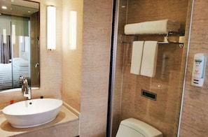 A bathroom with a white sink, a glass shower enclosure, and a towel rack. - Vienna International Hotel (Quanzhou)