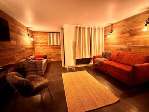 Una sala de estar acogedora con un sofá, un sillón y una alfombra.