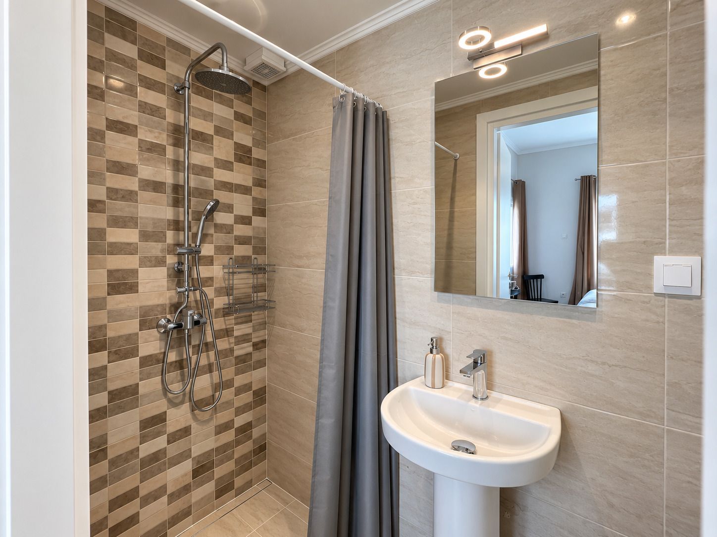 Une salle de bain avec une douche, un lavabo et un miroir.