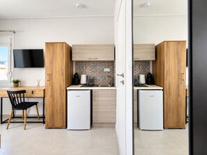 A modern kitchen with two white refrigerators, wooden cabinets, a black chair, and a tiled backsplash. - 6th Floor Loft in the Heart of Athens ΙΙ by ΜΡS (Athina)