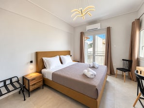 A hotel room with a bed, bedside table, chair, and a view of the outside. - 6th Floor Loft in the Heart of Athens ΙΙ by ΜΡS (Athina)