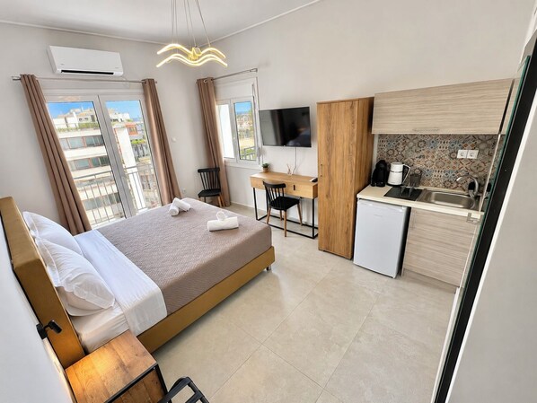 Une chambre d’hôtel équipée d’un lit, d’un bureau, d’une kitchenette et d’un téléviseur.