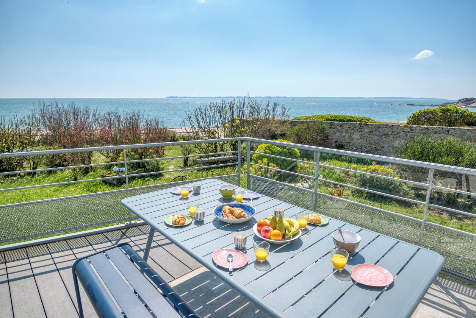 A table set with breakfast items and a scenic ocean view.