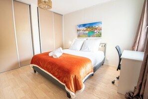 A hotel room with a bed, a desk, and a painting on the wall. - Modern beachfront house by Groom* (Larmor-Plage)