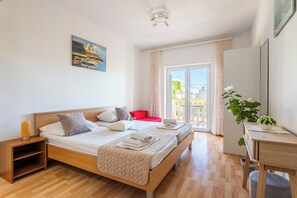 Un dormitorio con cama, mesita de noche y un cuadro en la pared.
