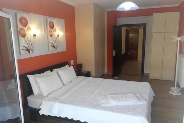 A bedroom with a large bed, a wardrobe, and a mirror. - Valena Studios Apartments (Lefkada)
