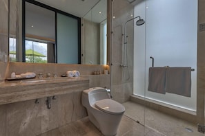 Une salle de bain moderne avec une douche à parois de verre, un meuble-lavabo en marbre et des toilettes.