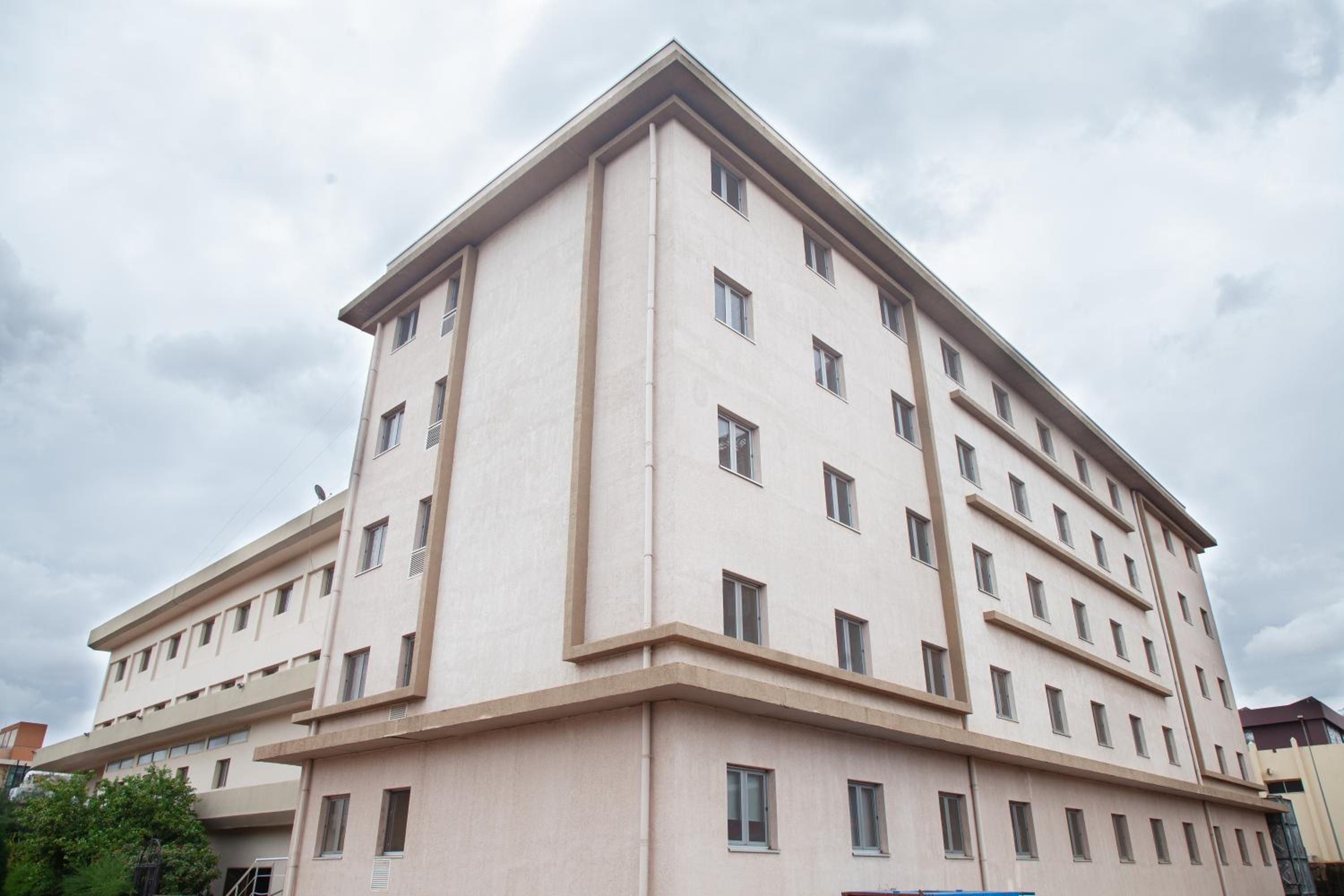 A multi-story building with a flat facade, rectangular windows, and a symmetrical design.