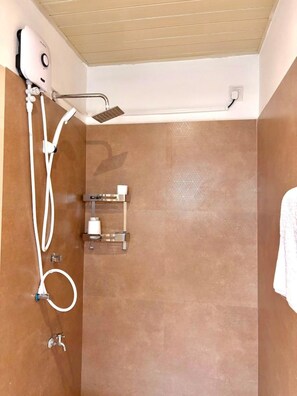 A shower with a handheld showerhead, a wall-mounted faucet, and a towel rack. - Nest Villas | Your peaceful stay in Colombo 7 (Colombo)