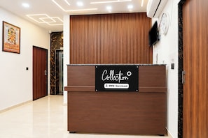 A reception desk with a sign indicating it is serviced by OYO.