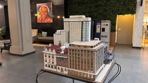 A model of a cityscape with various buildings, a bench, and a wall with greenery. - Cape Town – A Home Like No Other (Cape Town)