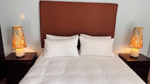 A hotel room with a large bed, two bedside tables, and lamps. - Cape Town – A Home Like No Other (Cape Town)