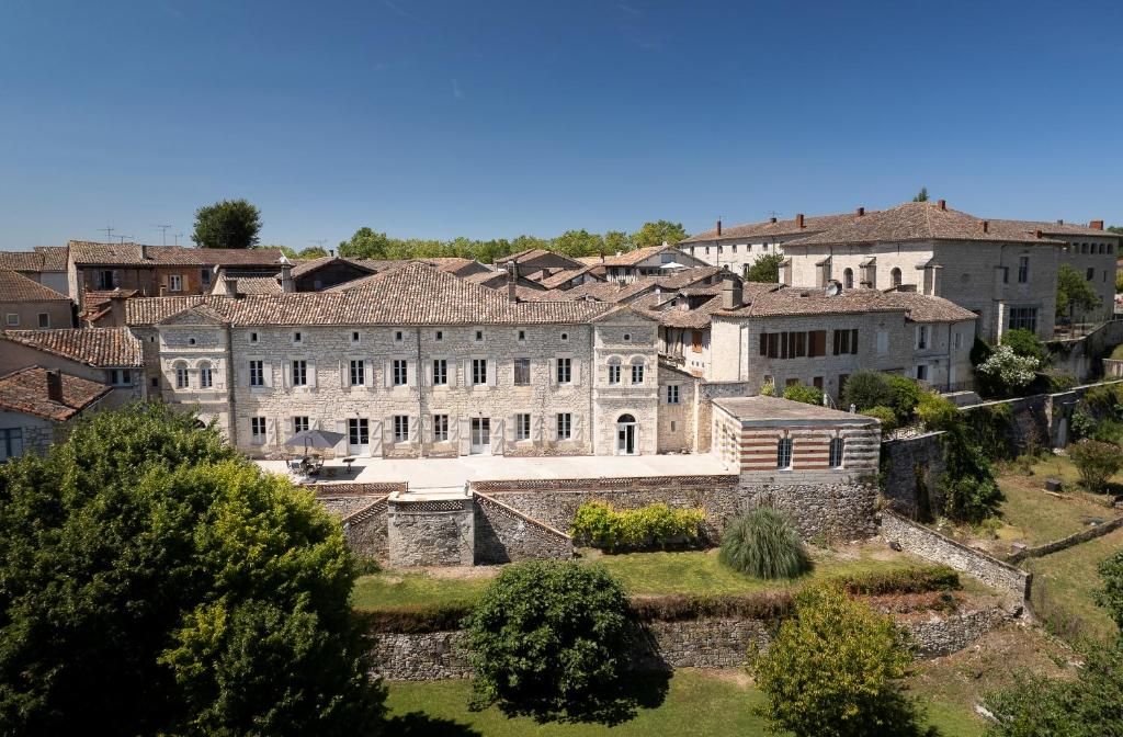 Un edificio storico in pietra con numerose finestre e un cortile interno.