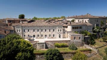 Un edificio storico in pietra con numerose finestre e un cortile interno.